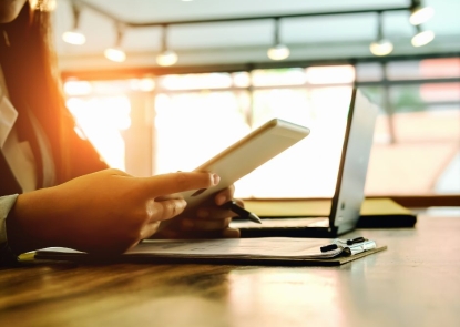 person working on a phone and laptop